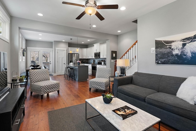 living area with dark wood-type flooring, ceiling fan, a healthy amount of sunlight, and recessed lighting