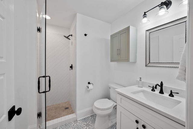 full bath featuring toilet, vanity, a stall shower, and baseboards