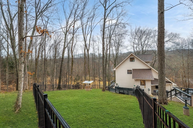view of yard featuring a wooded view and a fenced backyard