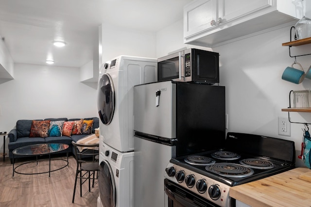 kitchen with stacked washer and clothes dryer, wood counters, wood finished floors, appliances with stainless steel finishes, and open shelves