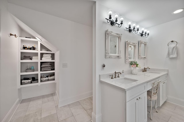 full bath featuring double vanity, a sink, and baseboards