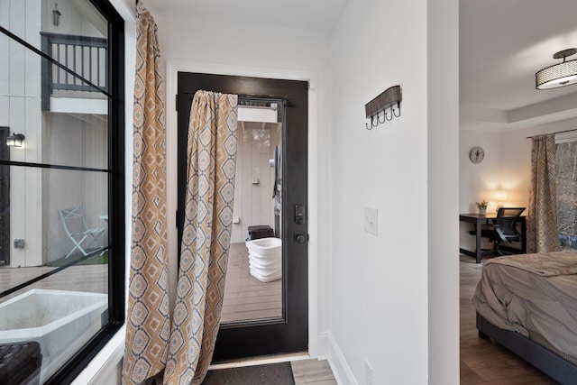 interior space featuring baseboards, ensuite bath, and wood finished floors