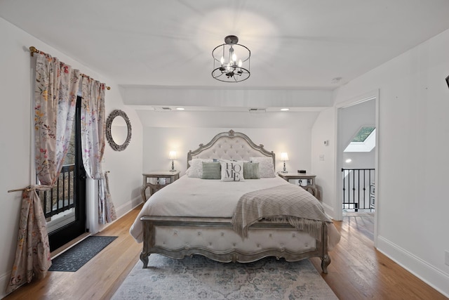 bedroom featuring light wood-style flooring, a notable chandelier, and baseboards