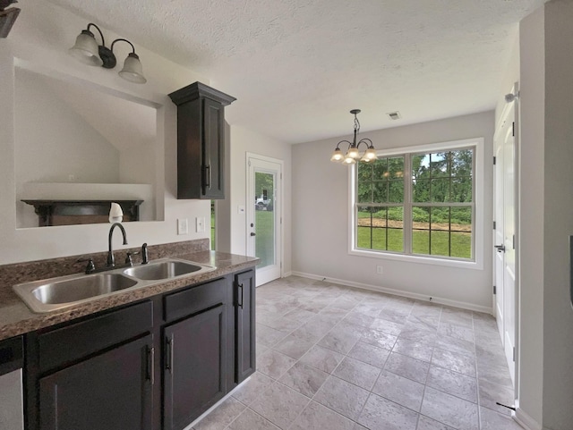 851 Salem Rd, Clarksville, TN 37040 - kitchen featuring a sink, a chandelier, hanging light fixtures, dark countertops, and baseboards
