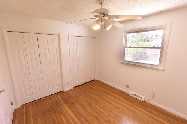 251 Sailboat Dr, Nashville, TN 37217 - unfurnished bedroom featuring light wood-type flooring, multiple closets, baseboards, a textured ceiling, and ceiling fan