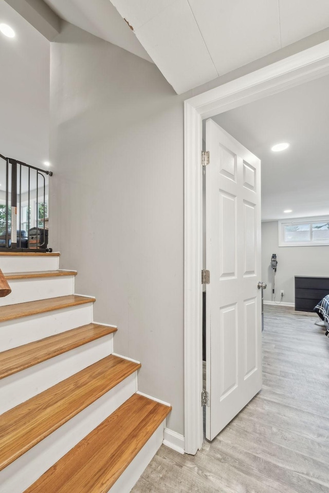 stairs featuring baseboards, wood finished floors, and recessed lighting