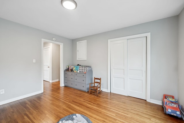 unfurnished bedroom with baseboards, a closet, and light wood-type flooring