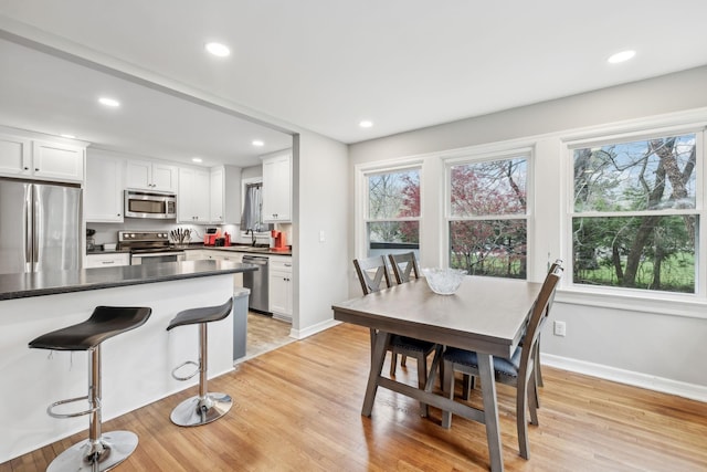 dining area with baseboards, light wood-style flooring, and recessed lighting