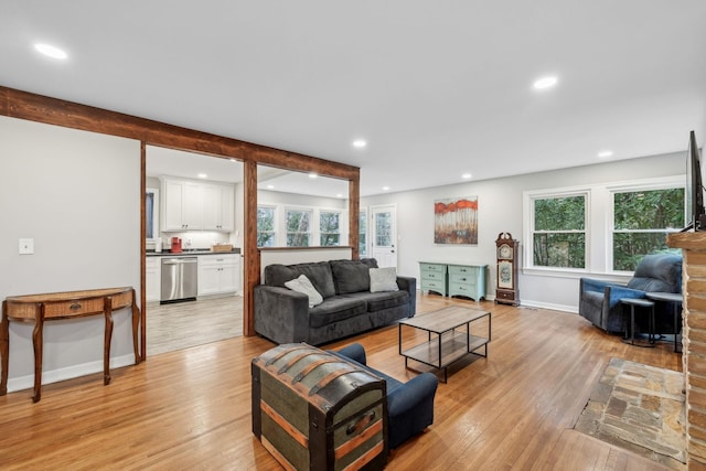 living area with a wealth of natural light, light wood-type flooring, and recessed lighting