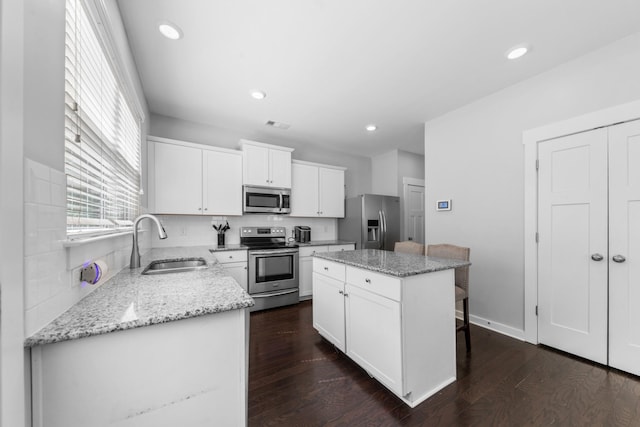 2037 Hamilton Hill Dr, Antioch, TN 37013 - kitchen with white cabinets, dark wood finished floors, a sink, a center island, and appliances with stainless steel finishes