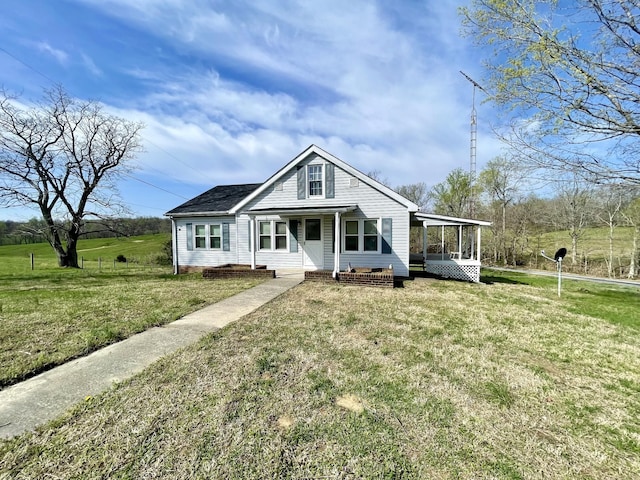 view of front facade featuring a sunroom and a front lawn