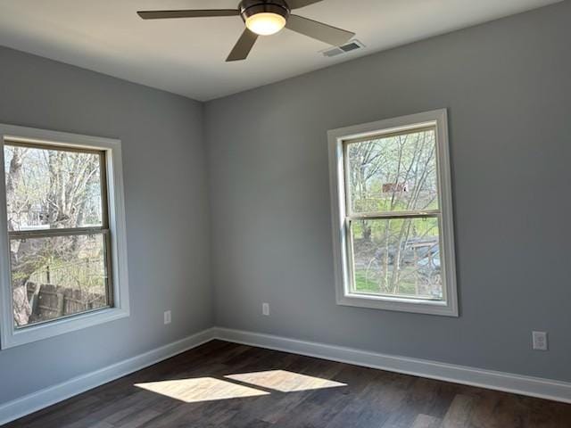spare room featuring a wealth of natural light, baseboards, and visible vents