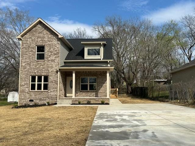 view of front of home with crawl space, driveway, covered porch, and brick siding
