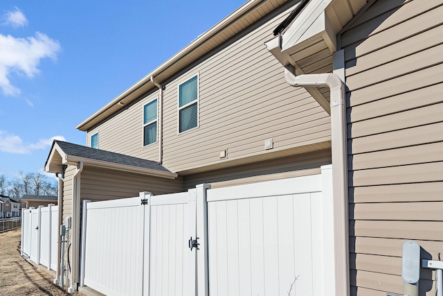 view of home's exterior with a gate, an attached garage, and fence
