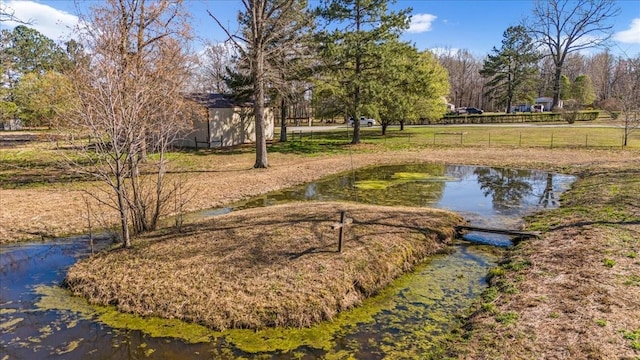 view of community featuring a water view and fence