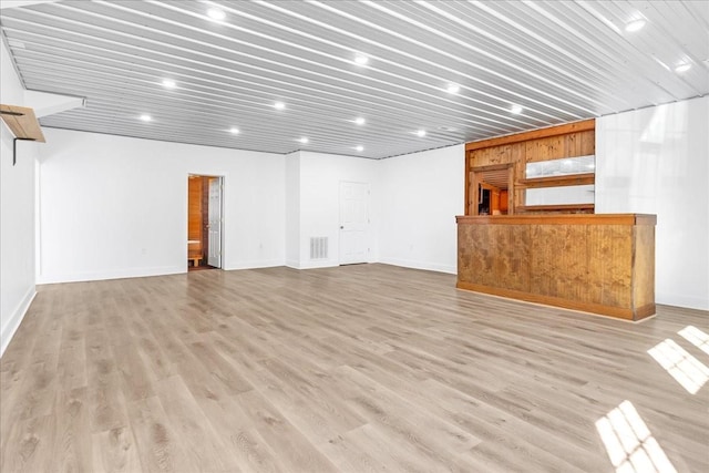 unfurnished living room with baseboards, visible vents, and light wood-style floors