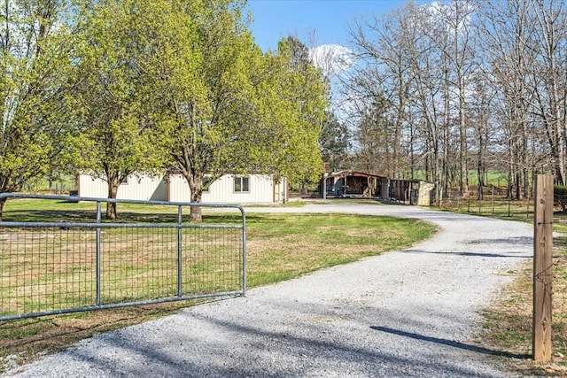 view of front of home with fence, gravel driveway, and a front yard