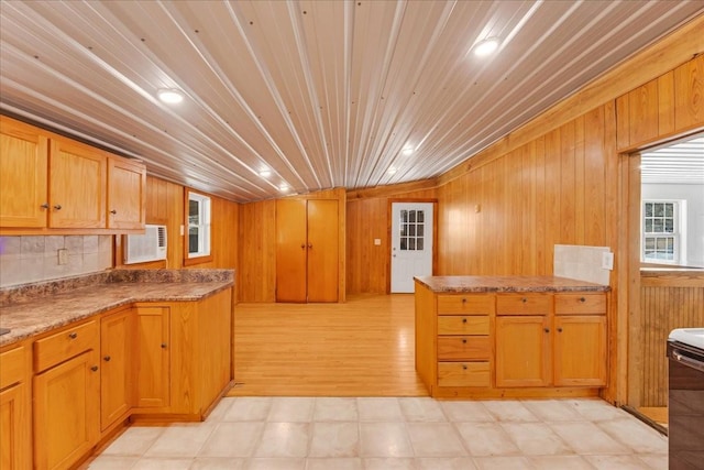 kitchen featuring brown cabinetry, a peninsula, wooden walls, stove, and wooden ceiling