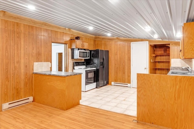 kitchen featuring a sink, electric stove, stainless steel microwave, and a baseboard heating unit