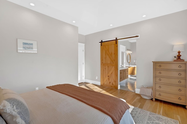 1017 Cliff View Dr N, Kingston Springs, TN 37082 - bedroom featuring connected bathroom, light wood-type flooring, recessed lighting, a barn door, and baseboards