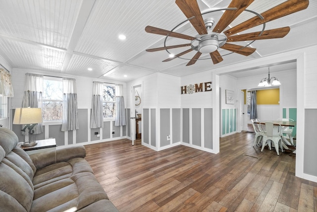 living room featuring ceiling fan with notable chandelier, a wainscoted wall, recessed lighting, and wood-type flooring