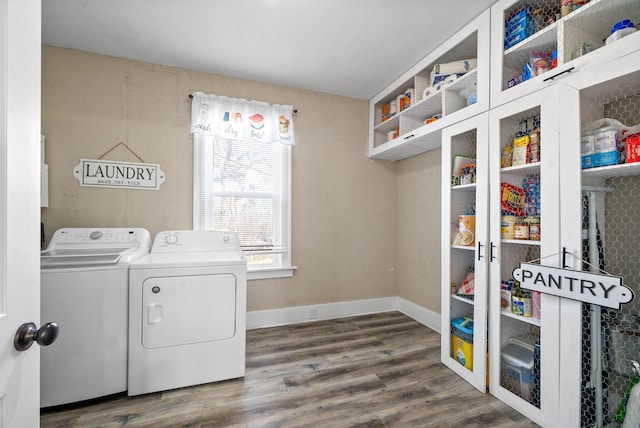 washroom with washer and dryer, baseboards, cabinet space, and wood finished floors