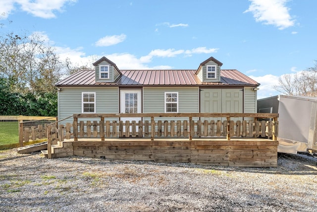 back of property featuring a deck and metal roof