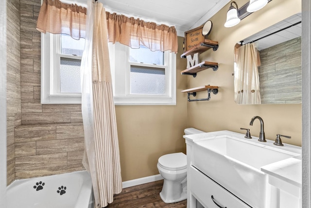 bathroom featuring toilet, a healthy amount of sunlight, wood finished floors, and baseboards