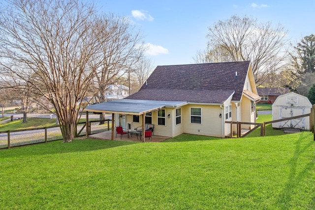 rear view of property featuring fence, a yard, a patio, and a storage unit