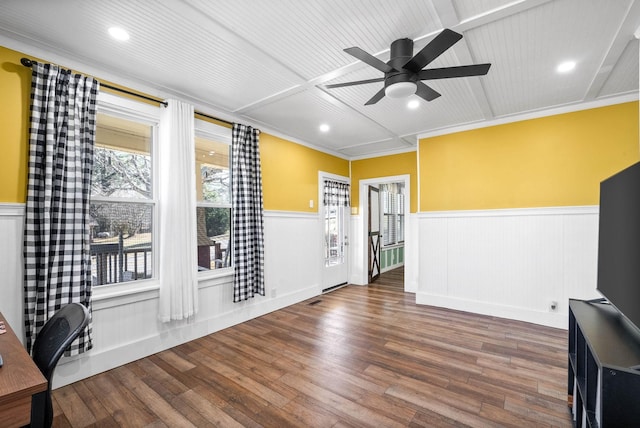 interior space with recessed lighting, wood finished floors, a ceiling fan, crown molding, and wainscoting