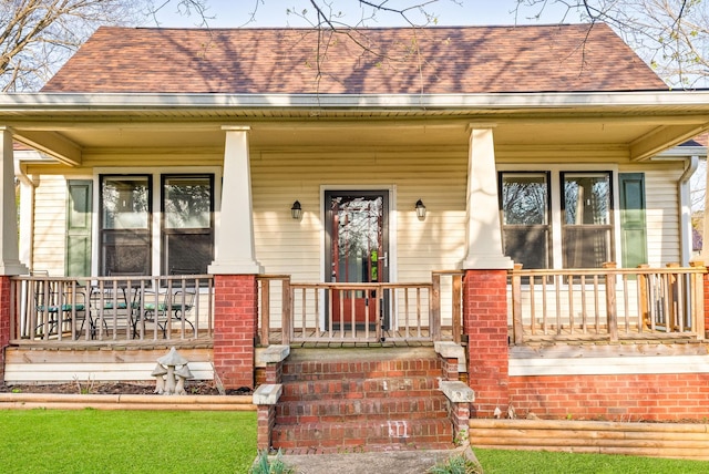 view of front of home featuring a shingled roof and covered porch