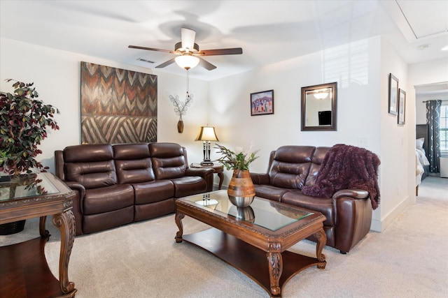 living room with attic access, light colored carpet, baseboards, visible vents, and a ceiling fan