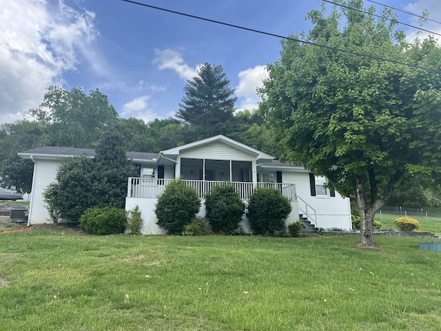 bungalow featuring a front lawn, a sunroom, and central AC