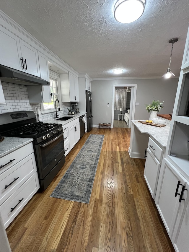 22 Jean Dr, Carthage, TN 37030 - kitchen with gas range, under cabinet range hood, a sink, a textured ceiling, and freestanding refrigerator