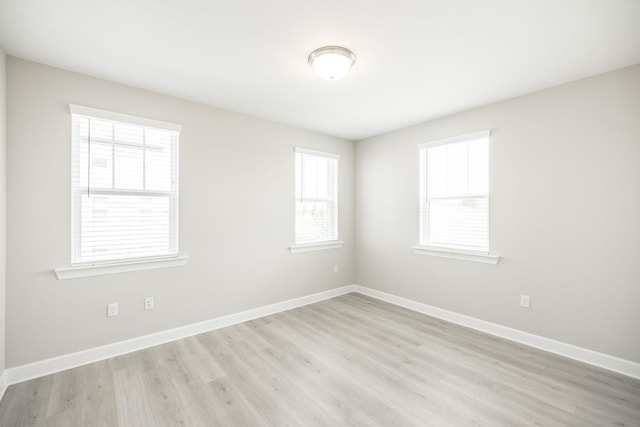 unfurnished room featuring baseboards and light wood-type flooring