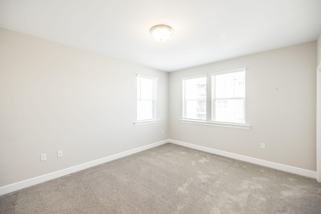 carpeted empty room featuring baseboards