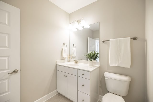 half bathroom featuring toilet, vanity, tile patterned floors, and baseboards