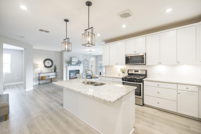kitchen with a sink, tasteful backsplash, appliances with stainless steel finishes, and visible vents