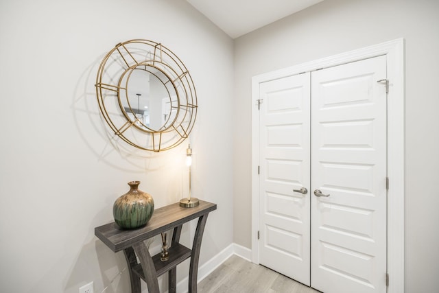 foyer with baseboards and light wood-style flooring