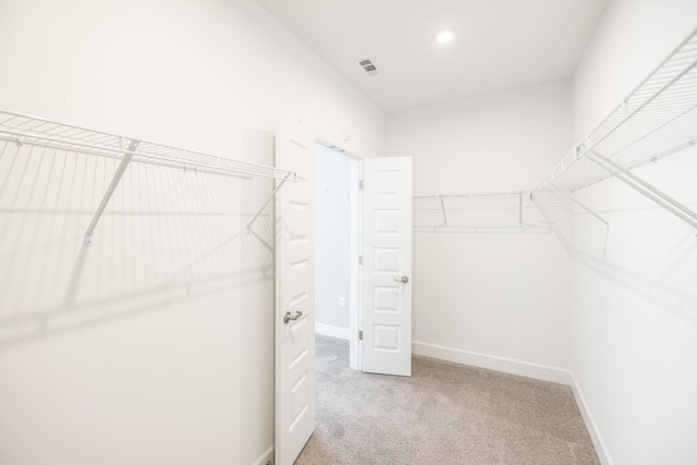 walk in closet featuring light carpet and visible vents
