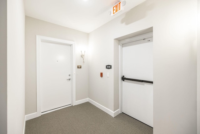 corridor with carpet flooring and baseboards