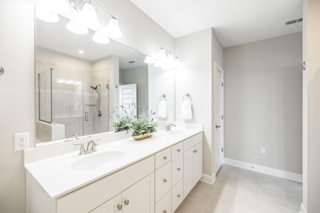 full bath featuring baseboards, a shower stall, a sink, visible vents, and double vanity