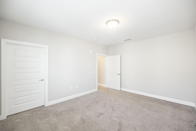 empty room with baseboards, carpet floors, and visible vents