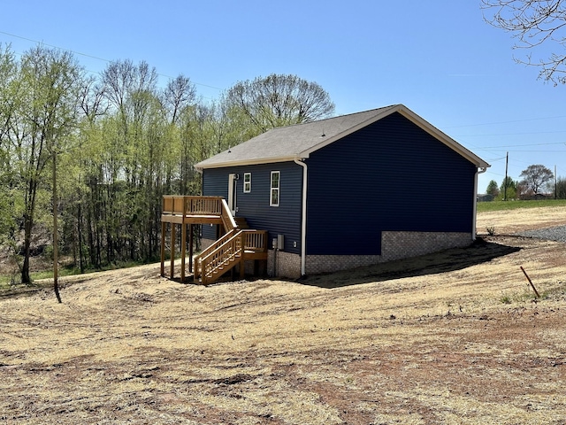 view of side of property with stairs and a wooden deck