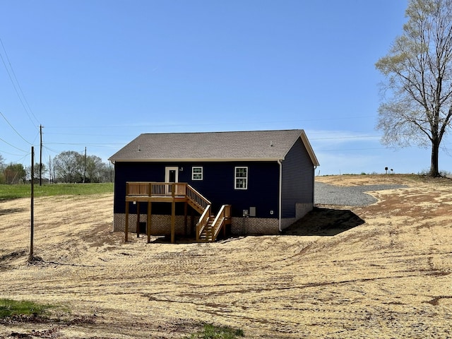 rear view of house with a wooden deck and stairway