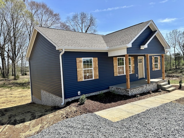 view of front of home with a shingled roof and a porch