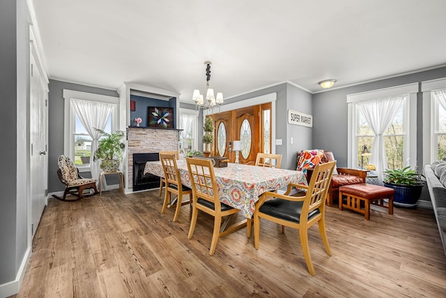 1036 Locke Creek Rd, Readyville, TN 37149 - dining area featuring a notable chandelier, ornamental molding, baseboards, light wood finished floors, and a stone fireplace