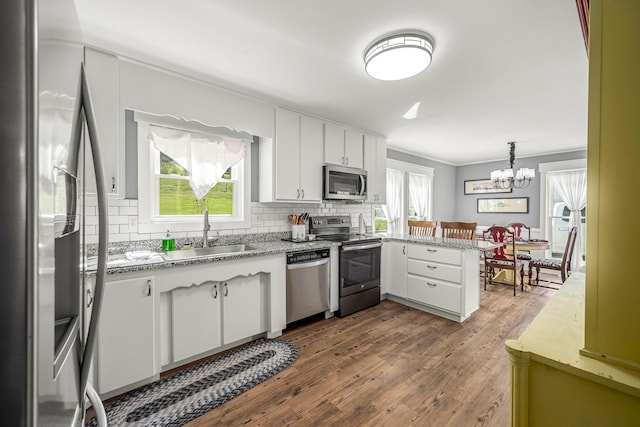 1036 Locke Creek Rd, Readyville, TN 37149 - kitchen with light countertops, a peninsula, appliances with stainless steel finishes, a sink, and backsplash
