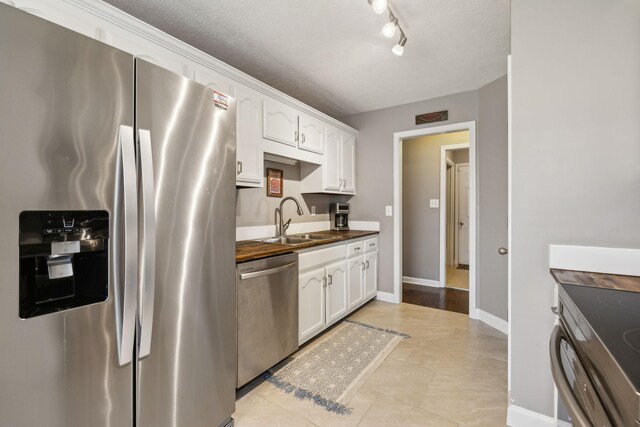 3648 S Jot Dr, Clarksville, TN 37040 - kitchen featuring white cabinets, a sink, stainless steel appliances, and a textured ceiling
