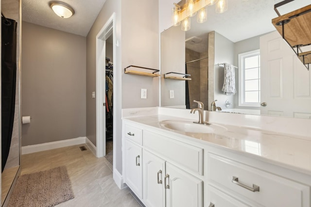 3648 S Jot Dr, Clarksville, TN 37040 - bathroom featuring a shower with shower curtain, vanity, a spacious closet, a textured ceiling, and baseboards